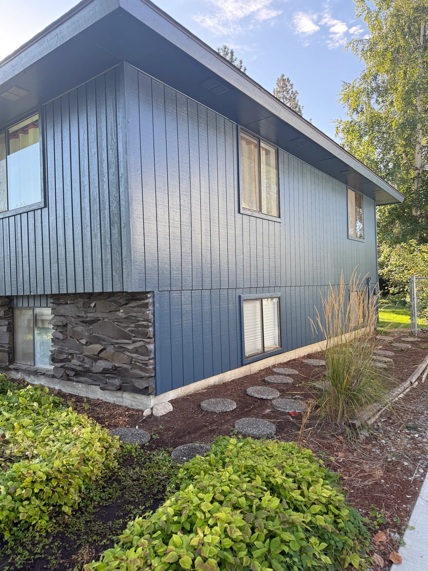 Completed blue exterior siding with stone accents